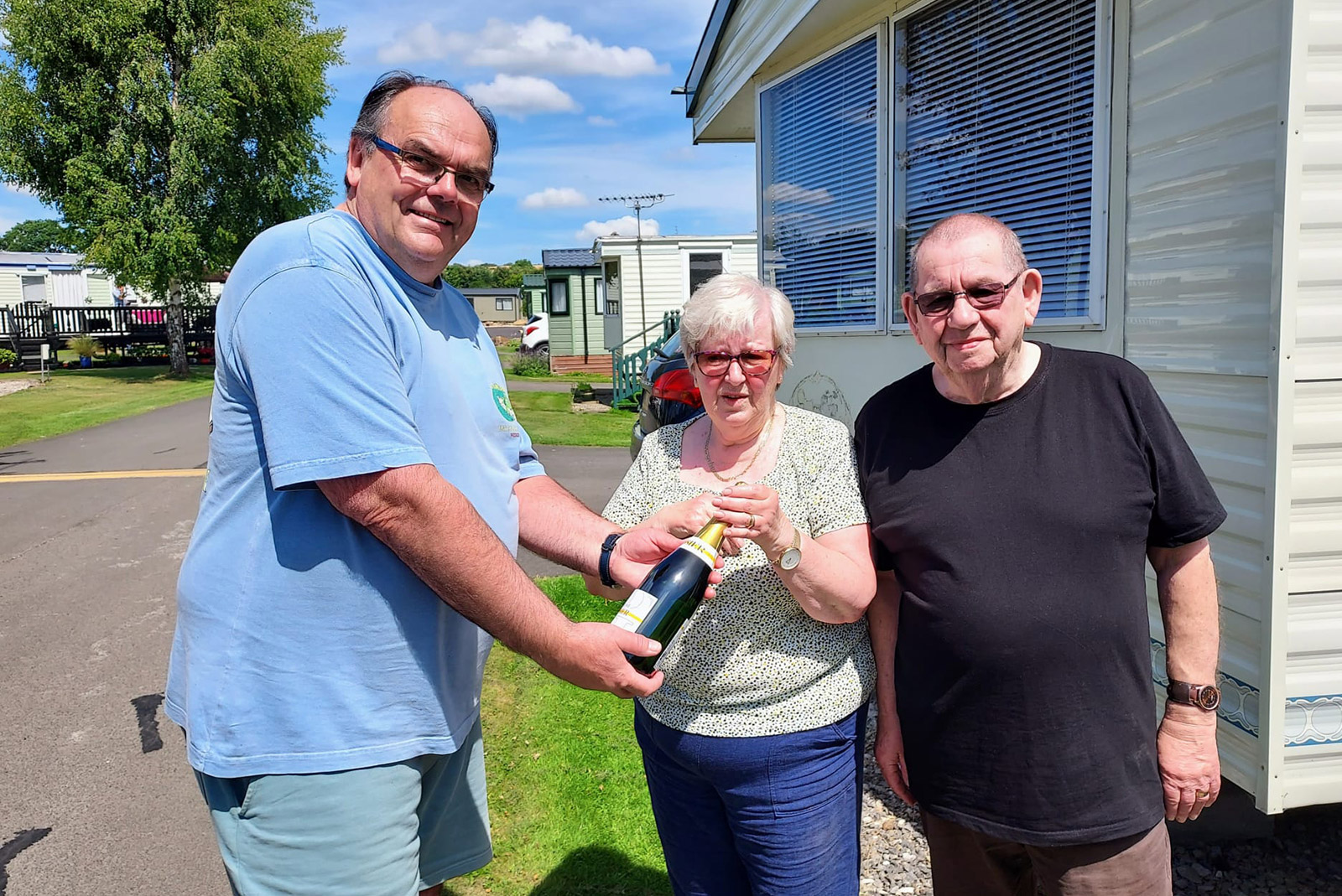 Mark Goodson presents Geoff and Elaine Dent with a very special bottle of champagne